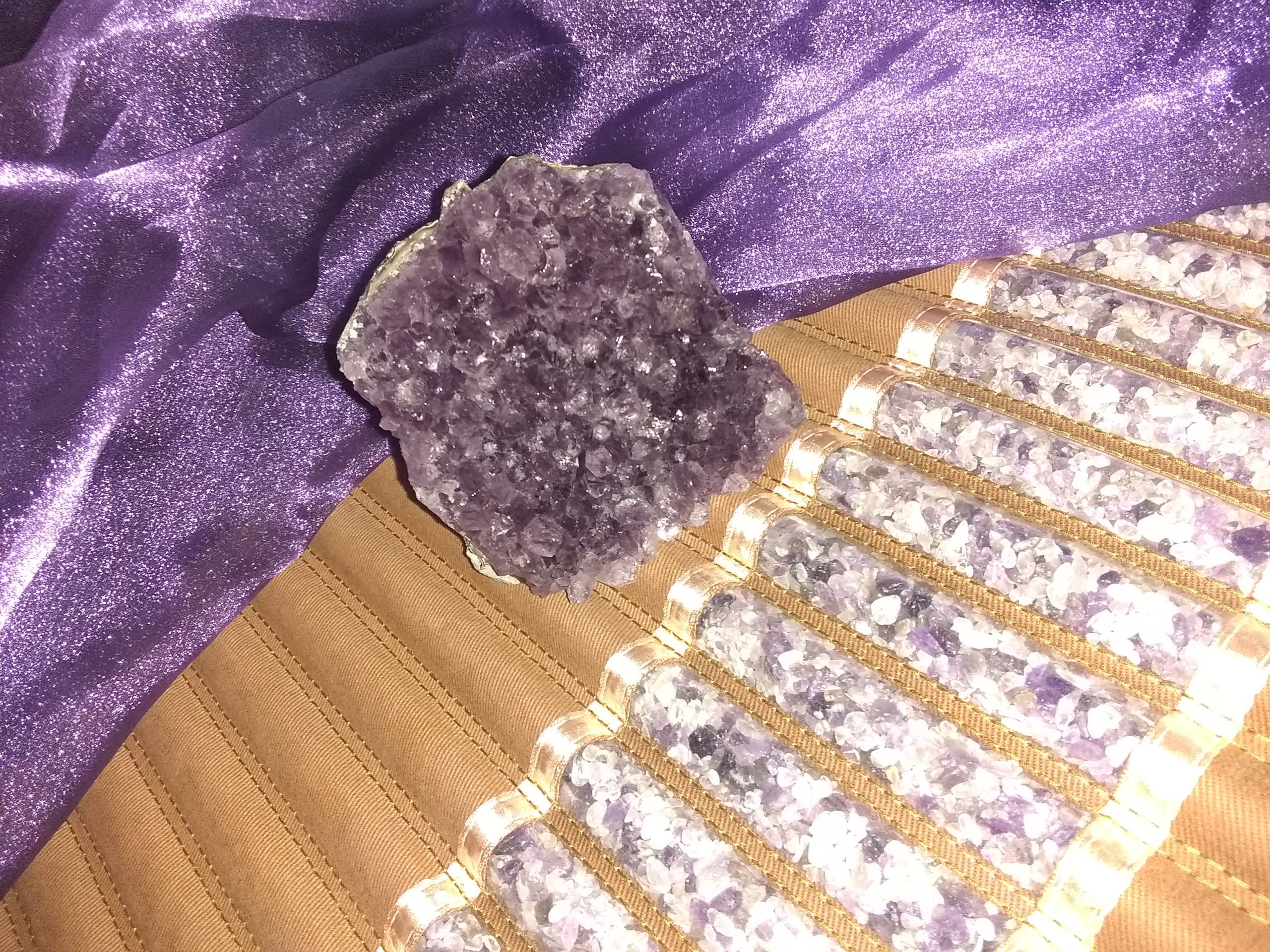 Raw amethyst cluster resting on an infrared Amethyst Biomat showing the internal crystal tubes