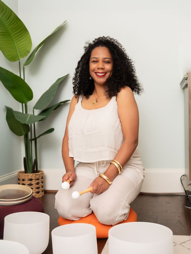 A wellness practitioner playing frosted quartz crystal singing bowls for vibroacoustic sound therapy